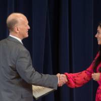 Dean Potteiger shaking hands with a graduate student and presenting them their award